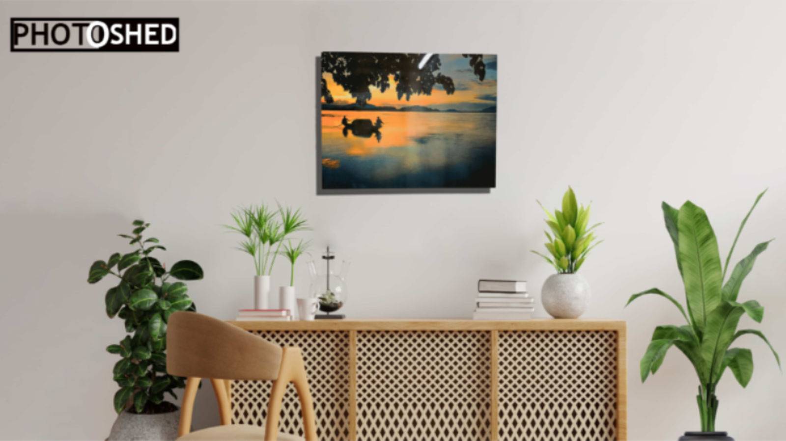 Decorative wall art of a sunset over water with ducks, placed above a wooden console table in a room with plants.